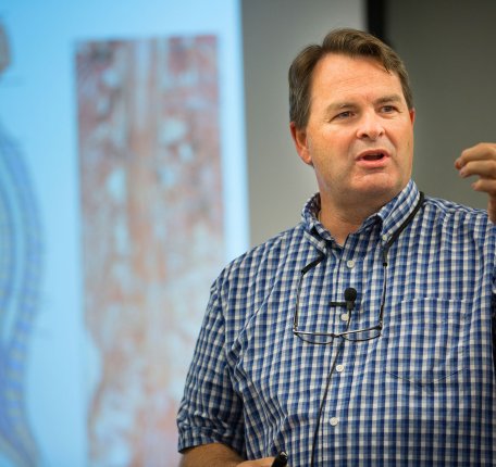 An instructor delivers a human anatomy and physiology lecture in front of projected anatomical diagrams.