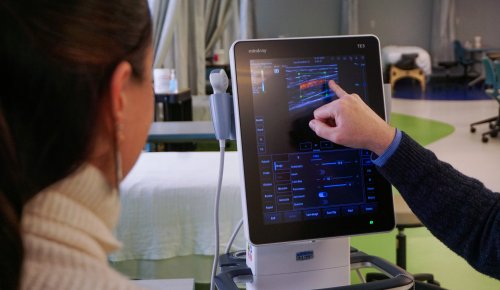 Close-up of a musculoskeletal ultrasound machine as a chiropractic faculty member points to real-time imaging on the screen while instructing a student in a clinical learning space.