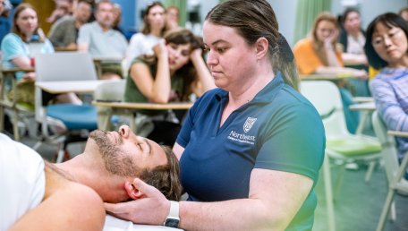 student giving a massage in a classroom on Seneca Falls campus