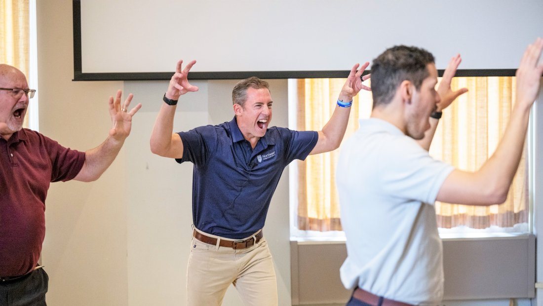 Dr. Kollmann leading the crowd in a roar to get them pumped