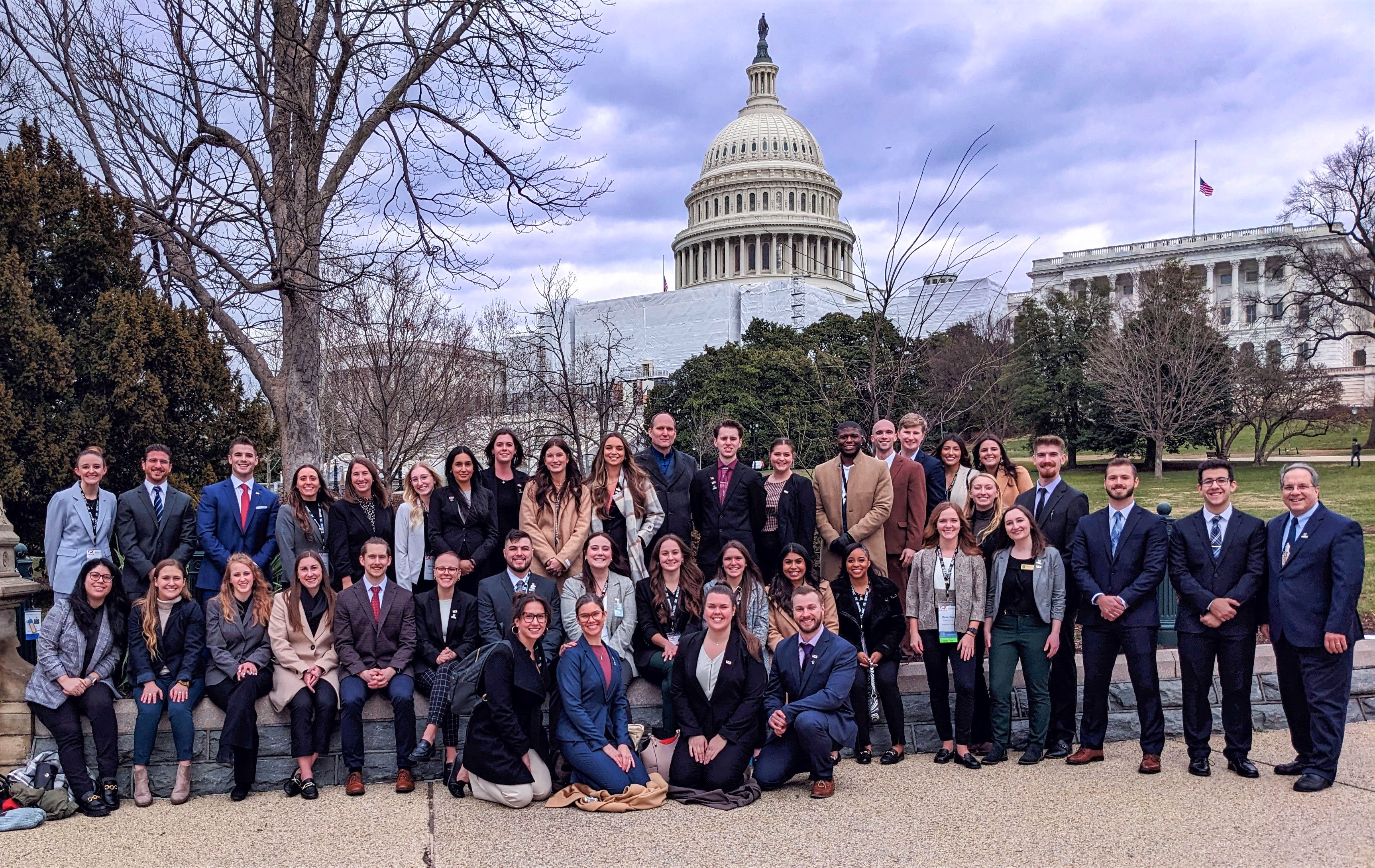 group of students and faculty posing in front of the Capitol Building