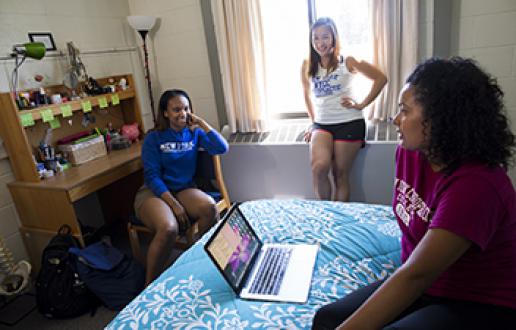Three people sitting in a dorm