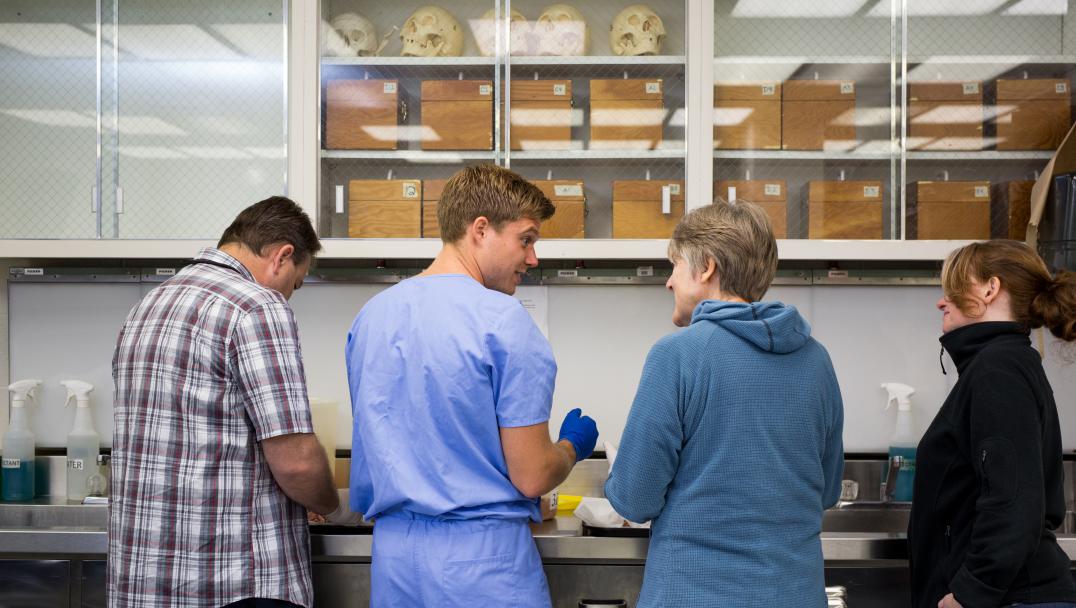 Students learning from a professor in the anatomy lab