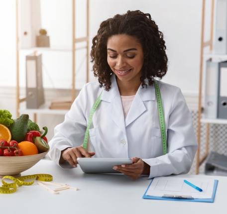 Nutritionist reviewing notes, sitting with a bowl of fruit