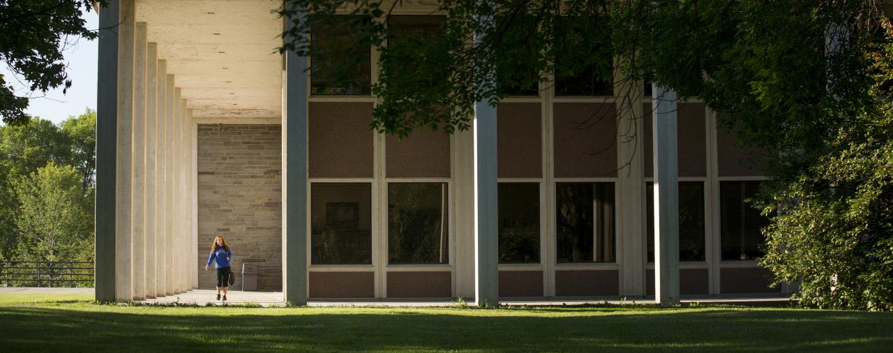 a student walking by a campus building