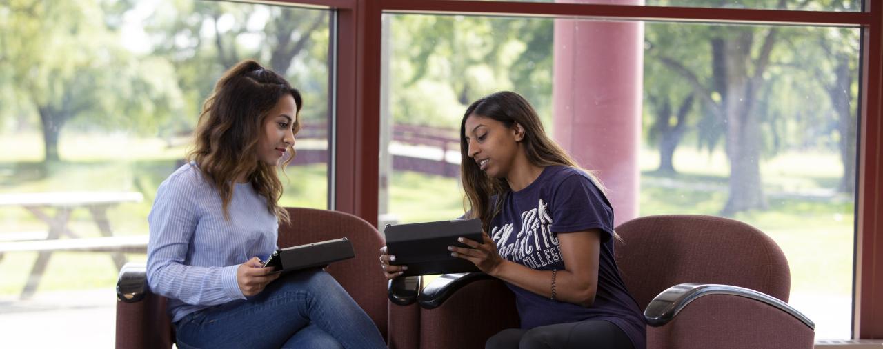 Two students looking at a tablet