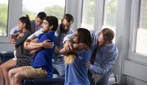 Northeast students providing chiropractic adjustments to each other