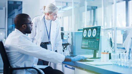 a radiologic technologist looks over x-ray images with a medical professional