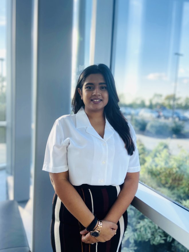 Yashvi Limbasiya posing and smiling by a window