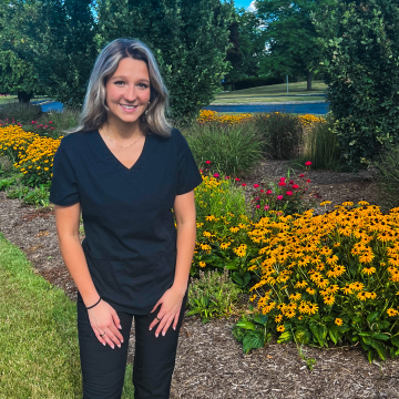 Bridget Ivanyi posing near a garden on campus