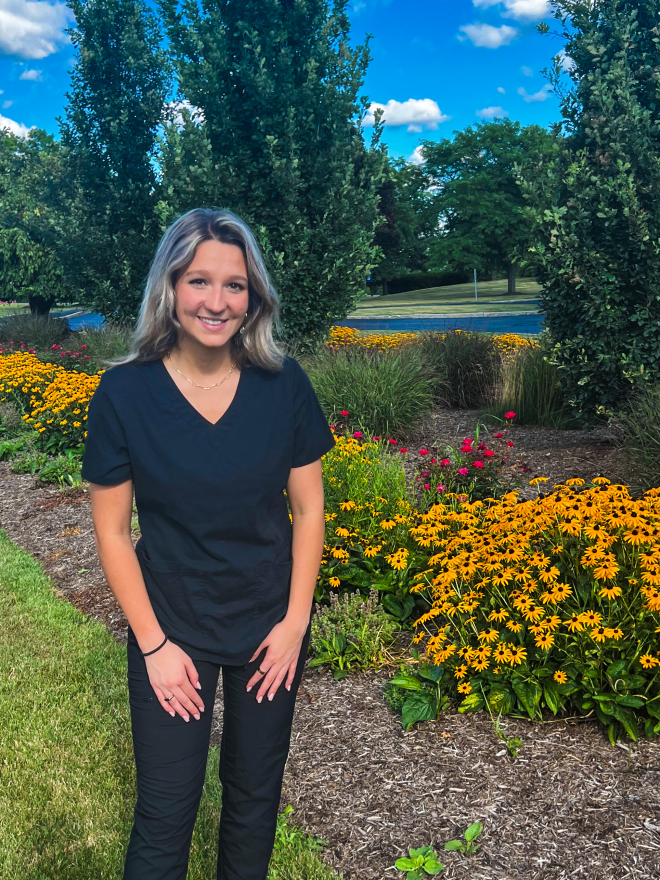 Bridget Ivanyi posing near a garden on campus