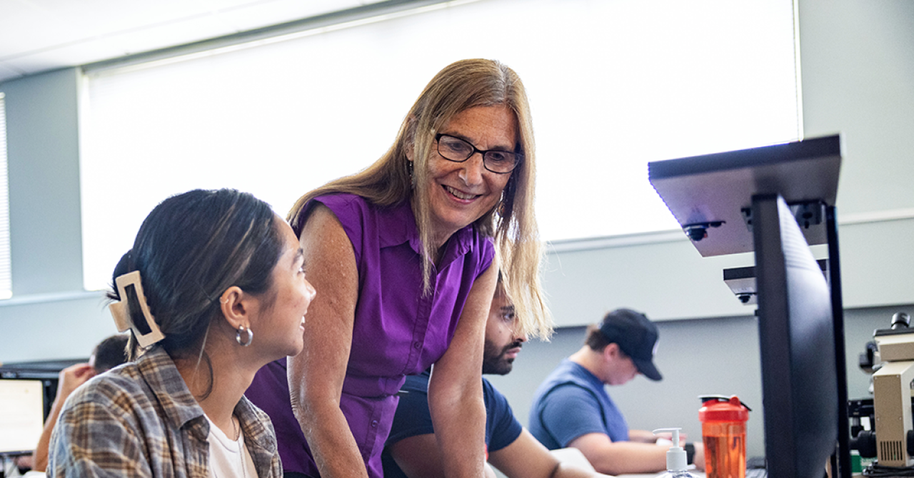 an instructor working with a student in the classroom