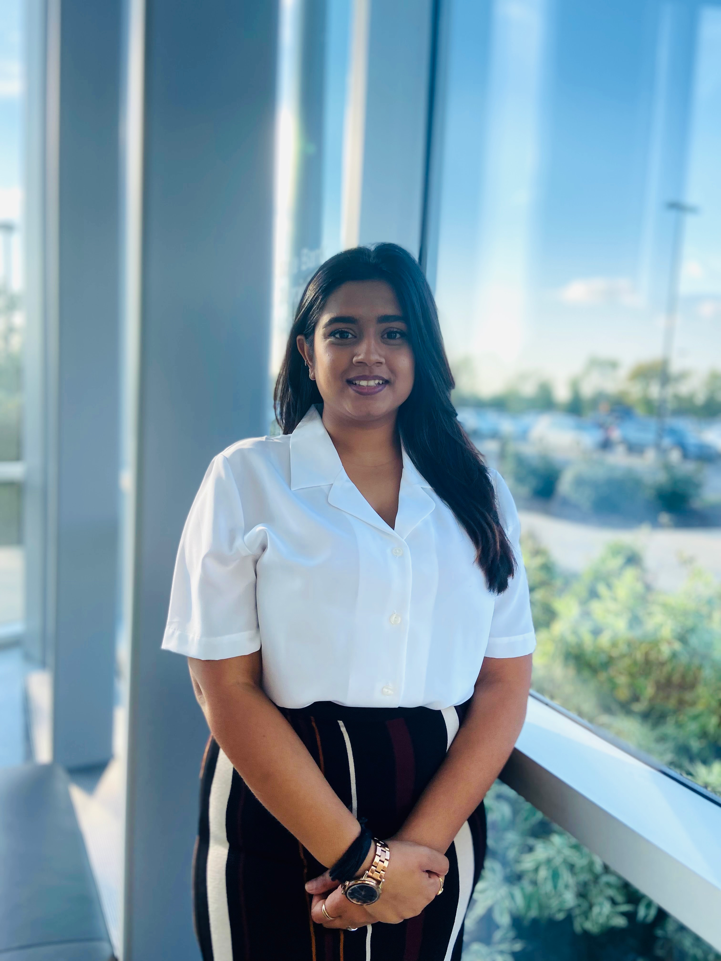 Yashvi Limbasiya posing and smiling by a window